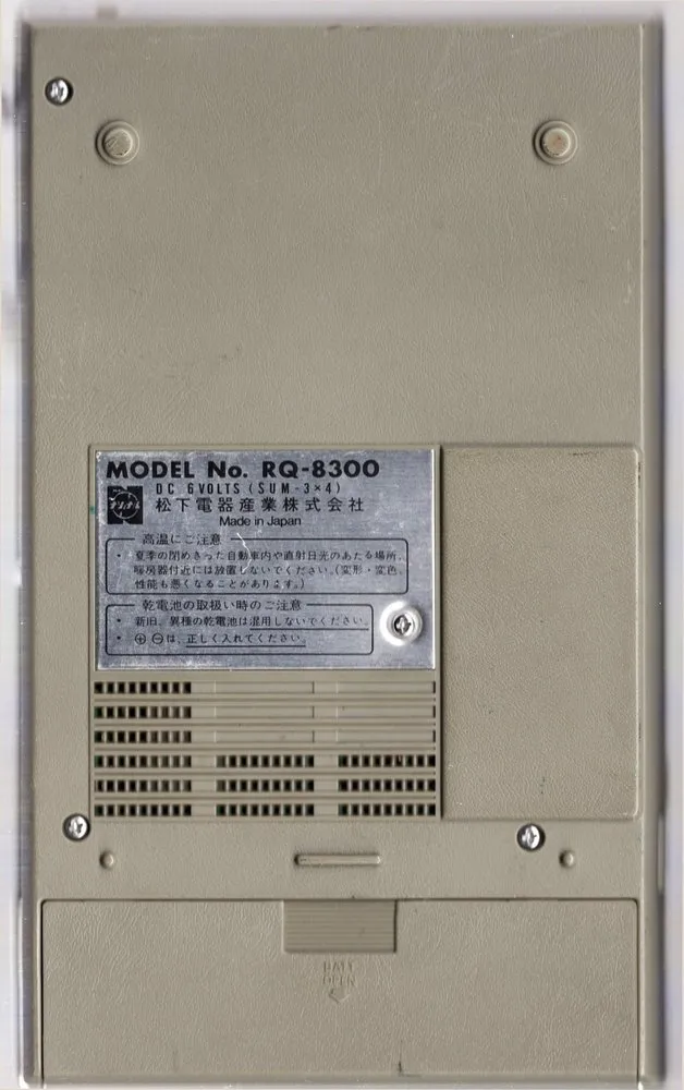 プログラムレコーダ RQ-8300 の背面。中ほどに銘板と注意書き、下に電池の蓋