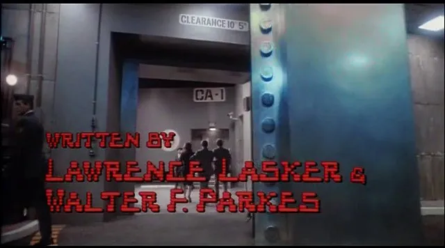 NORAD の扉の前の映像に、赤いドットの文字で「WRITTEN BY」「LAWRENCE LASKER &」「WALTER F. PARKES」