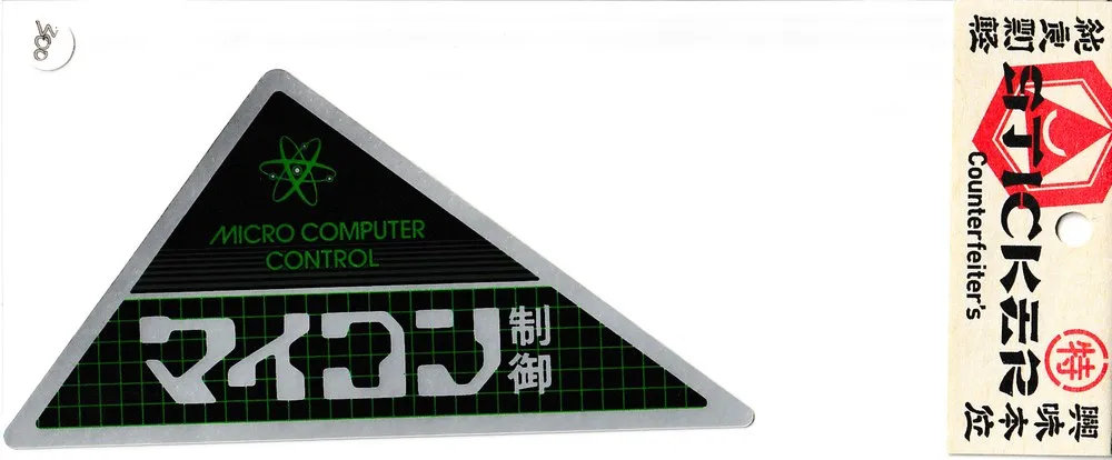 2020年版のステッカー。銀色の縁の直角三角形で、上に原子のマークと「MICRO COMPUTER CONTROL」、下の緑の方眼の地に「マイコン」「制御」。右に Counterfeiter’s の台紙のヘッダー